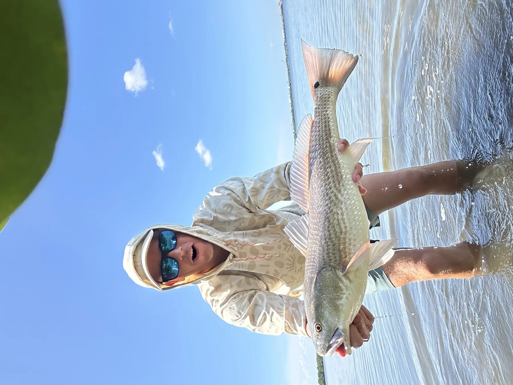 Person holding a fish outdoors